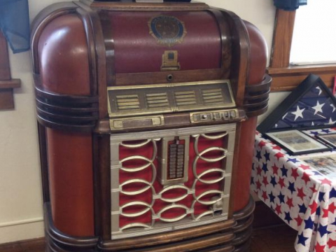 Antique juke box with 75th anniversary whiskey bottles